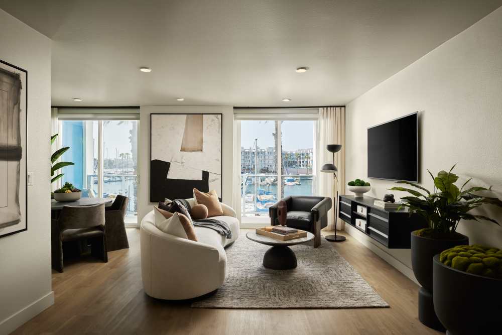 Living room with couch and TV at Dolphin Marina Apartments in Marina Del Rey, California