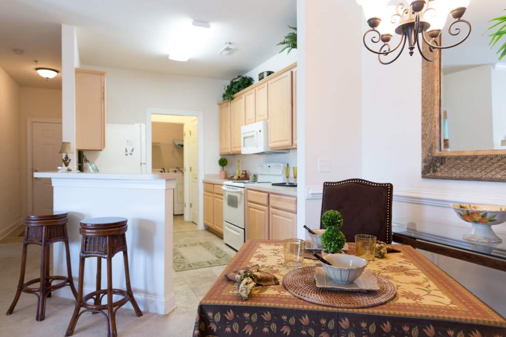 A set dining table next to an apartment kitchen at Cloisters at Carolina Forest in Myrtle Beach, South Carolina