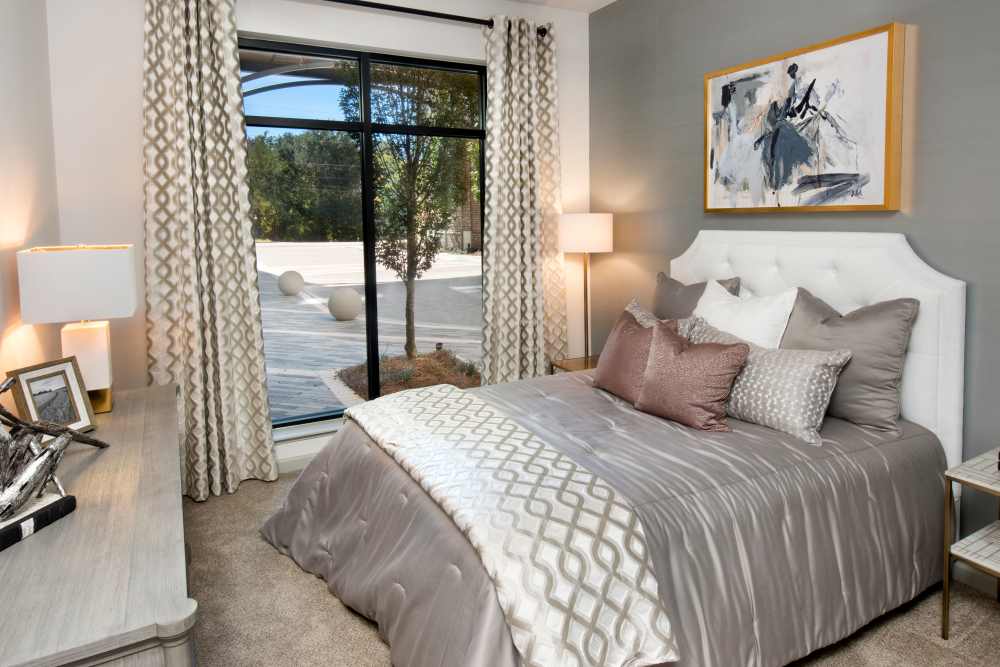 Cozy bedroom with large windows in a model home at The Mill at Westside in Atlanta, Georgia