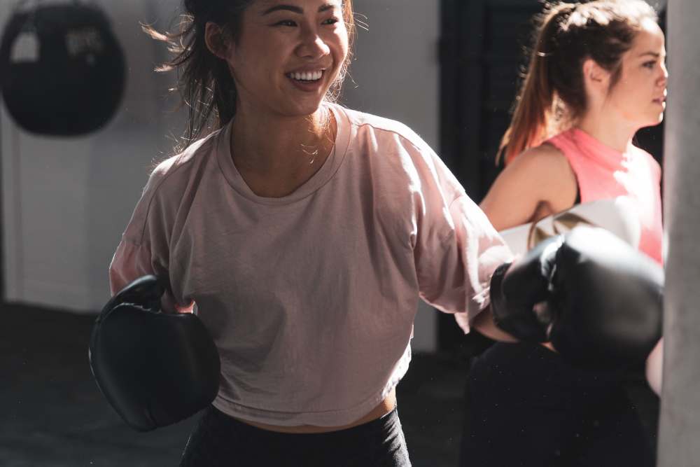 Two women hitting punching bags in a gym near The Mill at Westside in Atlanta, Georgia