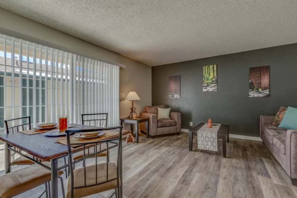 Modern living room with wood-style flooring, classy furniture & large vertical blinds at Kirman Garden in Reno, Nevada