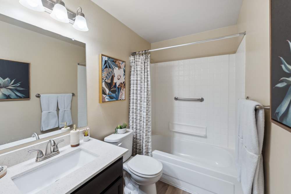 Clean model bathroom with a bathtub and shower at Madison Sammamish Apartments in Sammamish, Washington