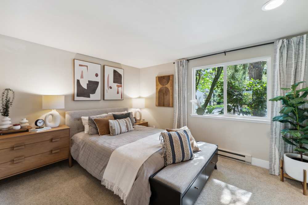 Cozy bedroom with plush carpeting and lots of natural light at Madison Sammamish Apartments in Sammamish, Washington