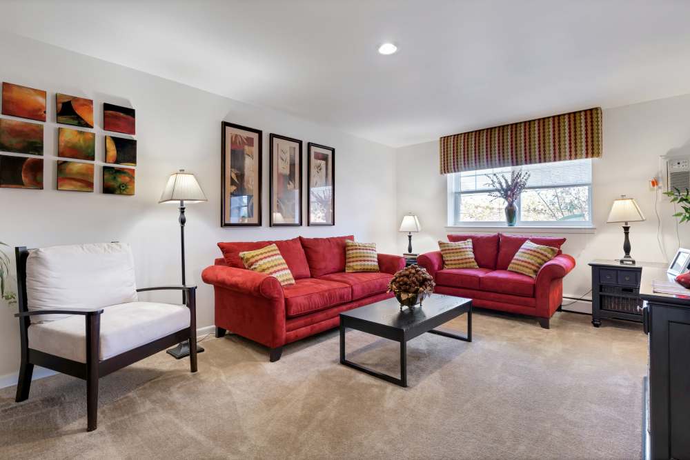 Comfortable living room with red sofa set and vase on top of the coffee table at Congress Apartment Homes in Allentown, Pennsylvania