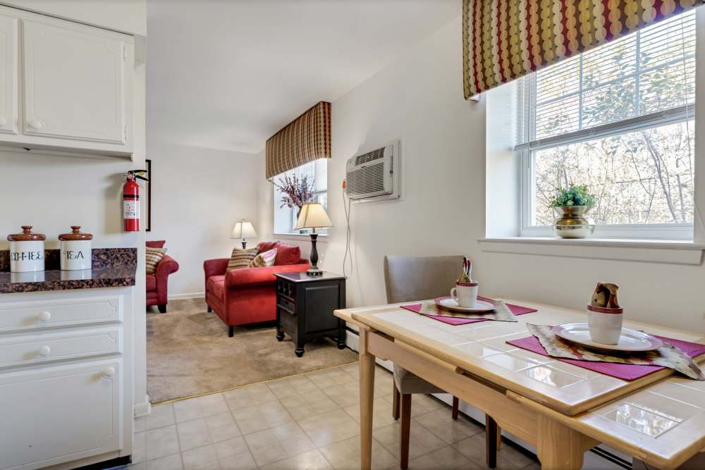 Open kitchen with dining table and a view of the living room at Congress Apartment Homes in Allentown, Pennsylvania