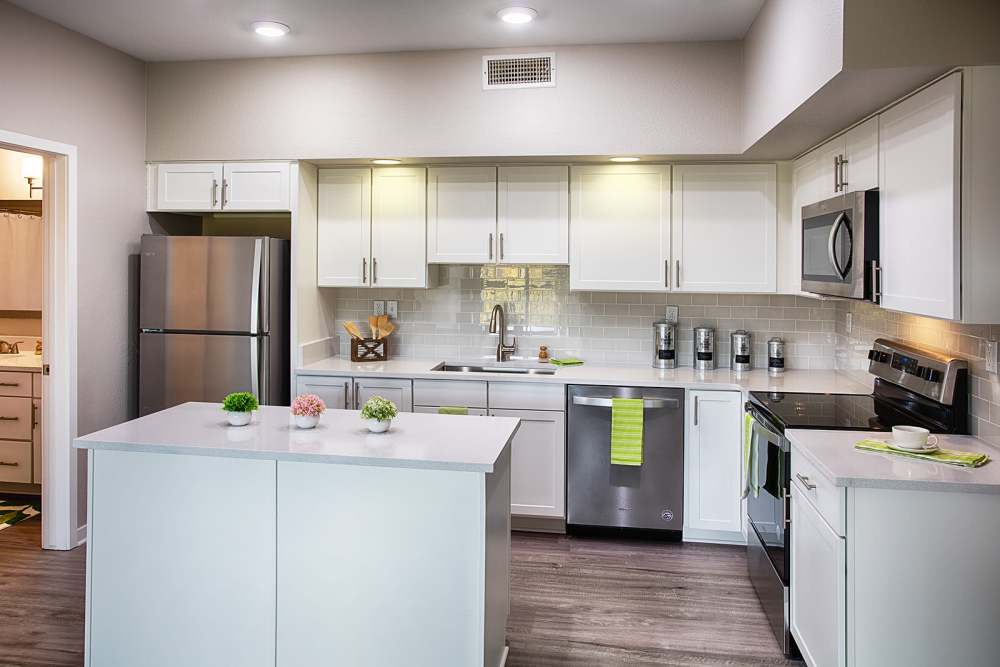 Renovated kitchen with stainless steel appliances and white cabinetry at The Greens at Van de Water in Loveland, Colorado