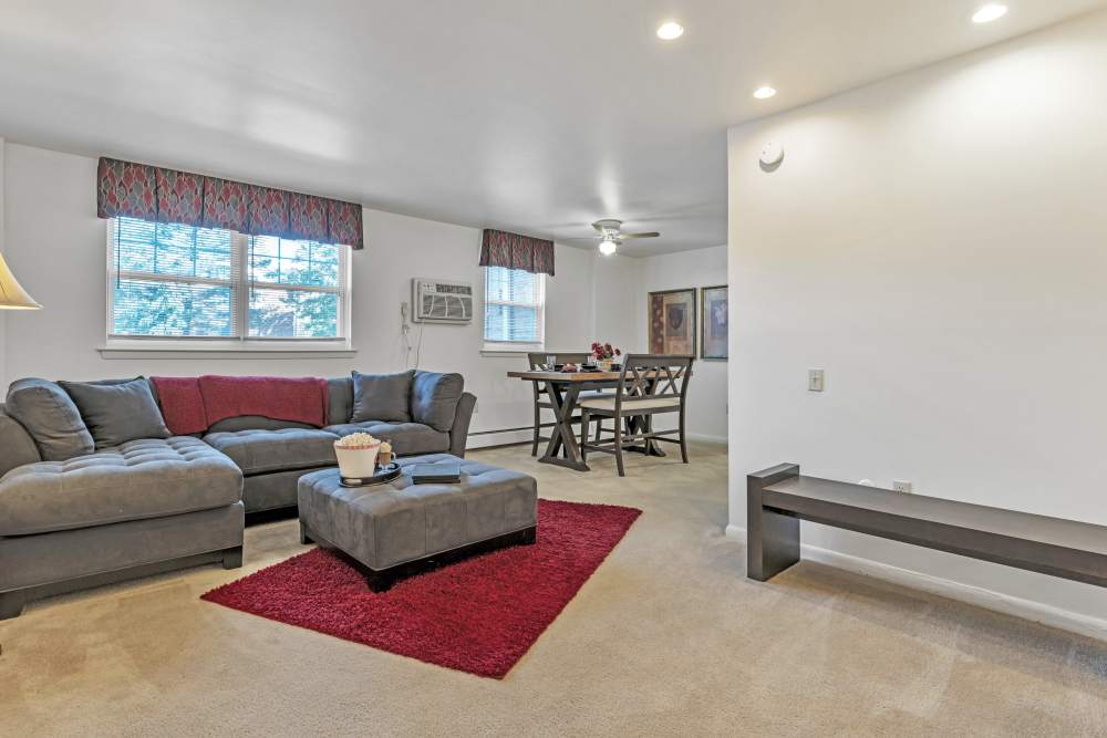 Cozy living room with sectional couch and dining area at South Mountain Apartment Homes in Allentown, Pennsylvania