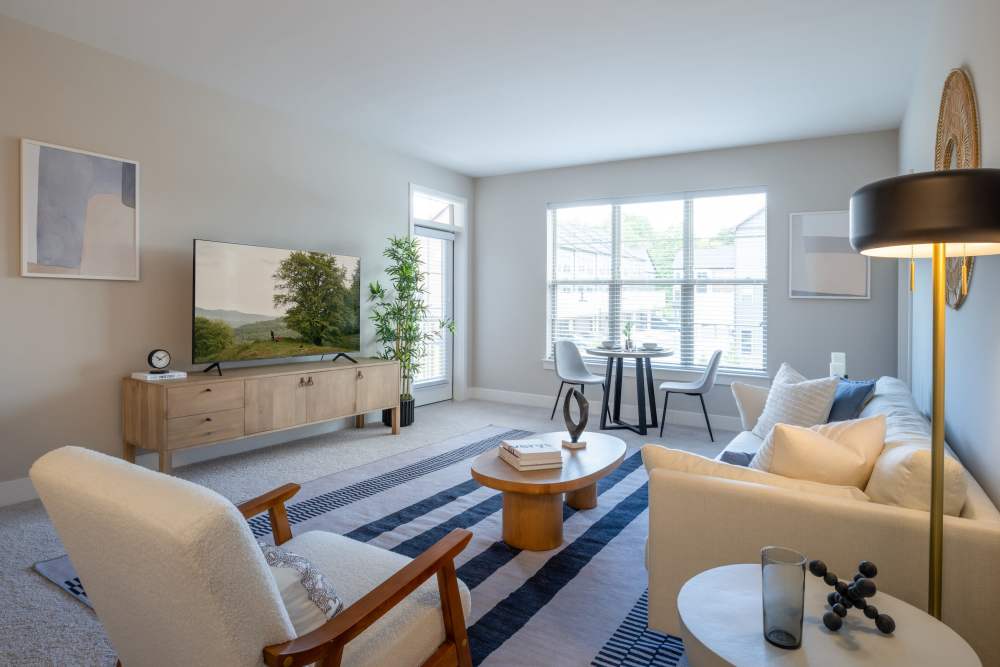 Spacious living rooms with hardwood-inspired flooring at Elms at the Refuge in Laurel, Maryland