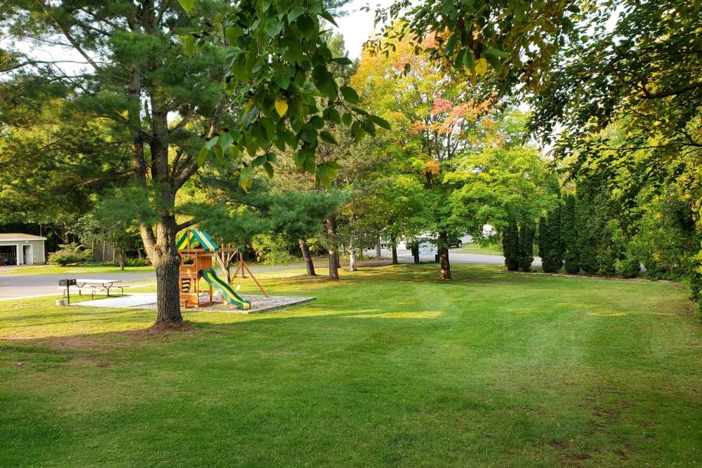 Children park with lots of trees and green lawn at Copper Hills Apartments in Houghton, Michigan,
