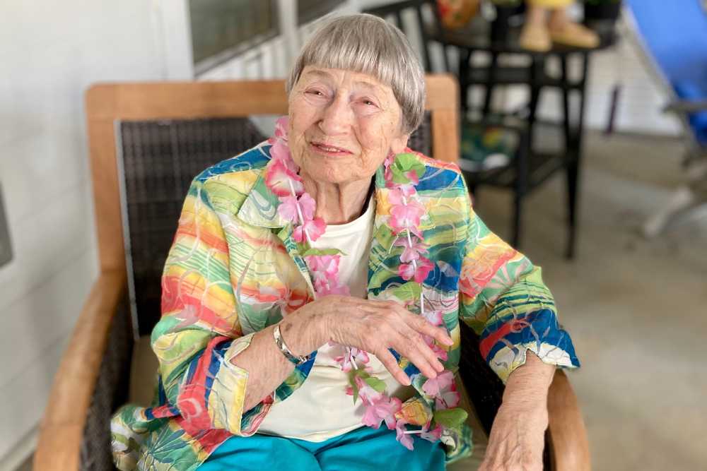 Resident in a colorful hawaiian button-up and wearing a floral necklace at Lighthouse Pointe in Chesapeake, Virginia