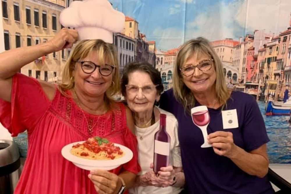 Caretakers posing with props for a photo with a resident at Nouveau Marc in Kenner, Louisiana