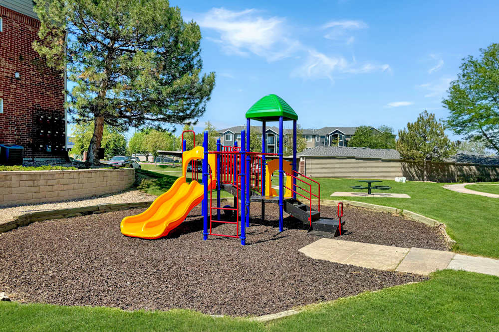 Building exterior with playground at Promenade at Hunter's Glen Apartments in Thornton, Colorado