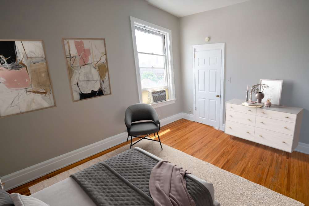 Well-lit bedroom with ceiling fan, large window, and hard-wood style flooring at À L'aise Hyde Park in Cincinnati, Ohio