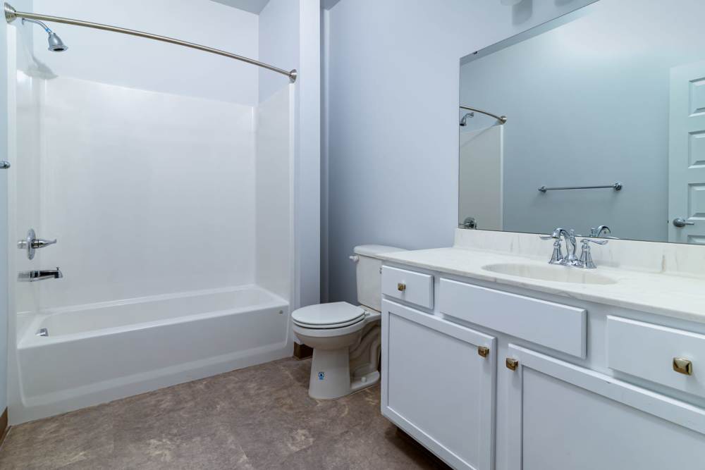 Bathroom with hard flooring, waterfall faucet sink, and storage space at Marketplace in Flint, Michigan