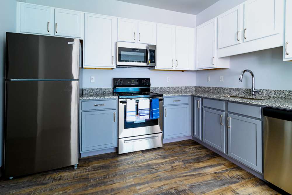 Spacious island kitchen, dishwasher, and wood cabinetry at Marketplace in Flint, Michigan
