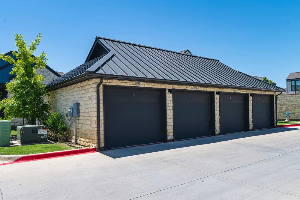 A garage with three garage doors at parcHAUS AT CELINA PARKWAY in Celina, Texas