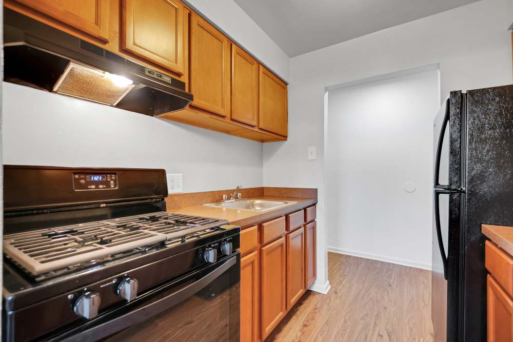 Kitchen with black appliances and wood-style flooring at Ridgeview Apartment Homes in Reading, Pennsylvania