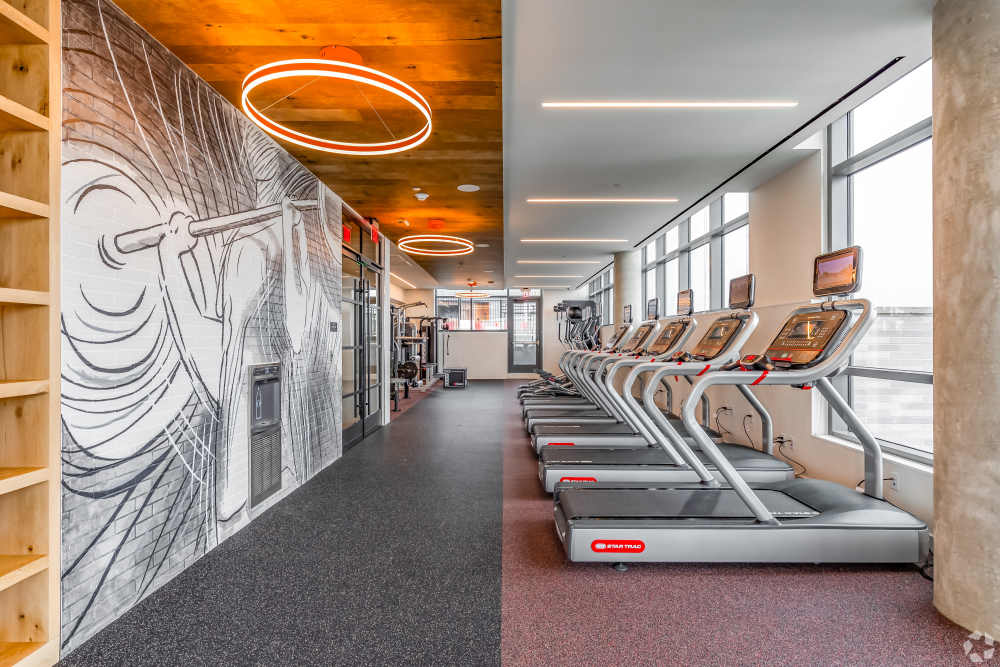 Fitness center showing a row of treadmills with floor to ceiling windows at Solaire 8200 Dixon in Silver Spring, Maryland