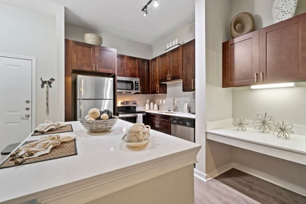 Fully equipped kitchen with stainless steel appliances and island at Flatiron District at Austin Ranch in The Colony, Texas