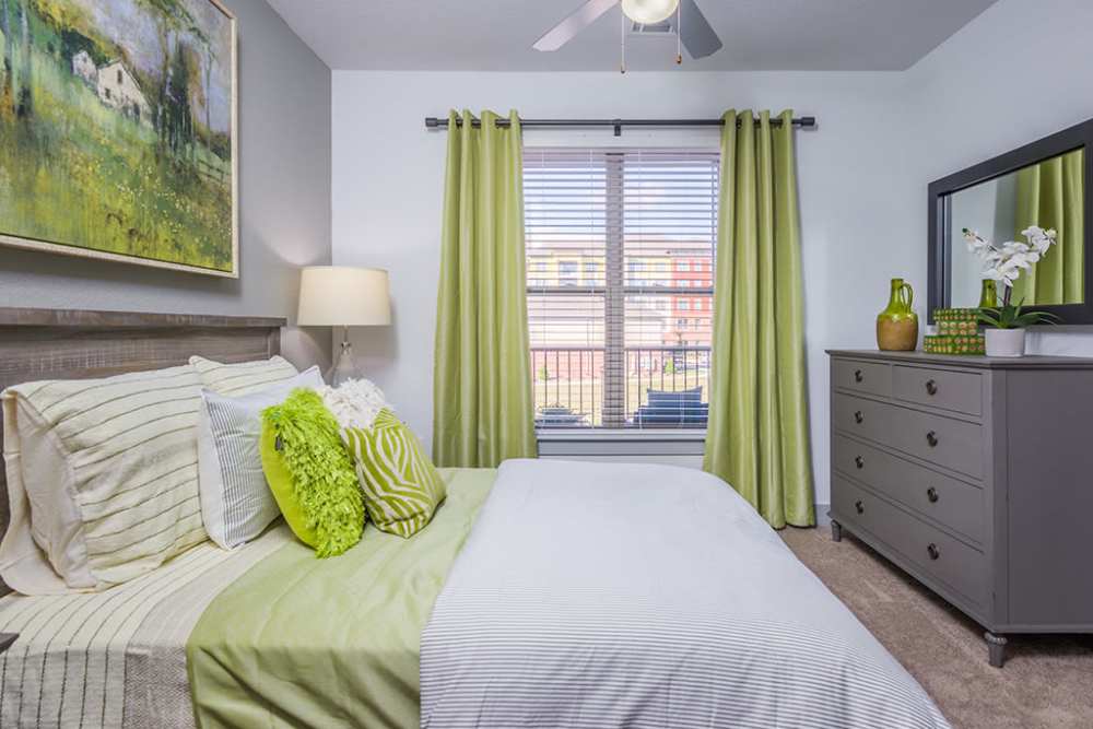 Bedroom with ceiling fan and large window in a model home at The District in Asheville, North Carolina