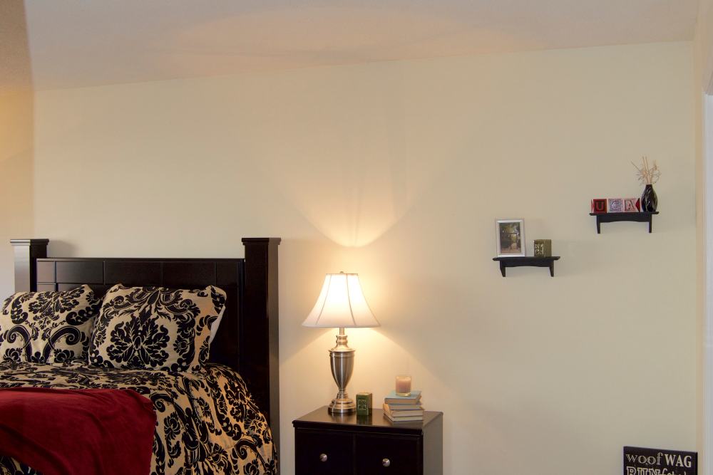 Bedroom with cozy bed in a model home at Cambridge Apartments in Athens, Georgia