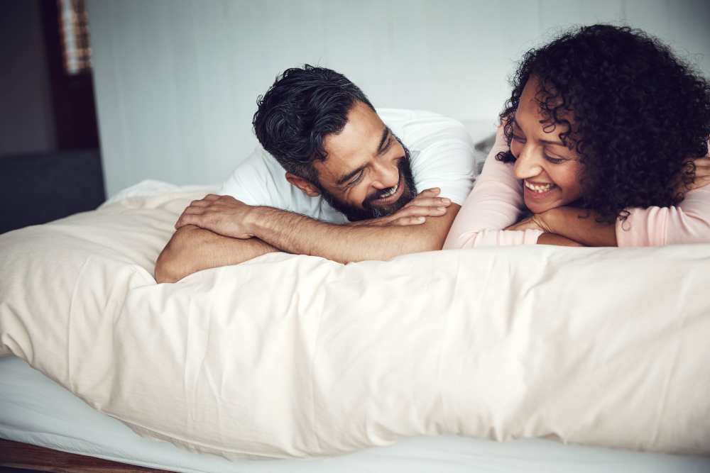Couple relaxing on their bed in their new home at The District in Asheville, North Carolina