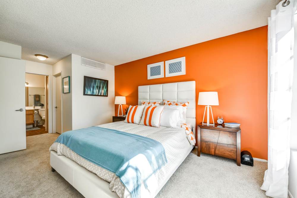 Spacious bedroom with an orange accent wall at Waterstone Media Center in Burbank, California