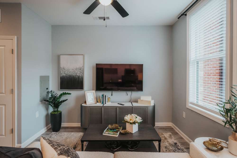 Living room with ceiling fan in a model home at The Addie in Savannah, Georgia