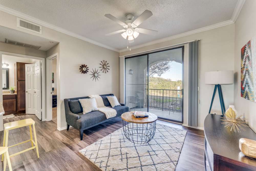 Living room with a door out to a private balcony at Cliffs at Barton Creek in Austin, Texas