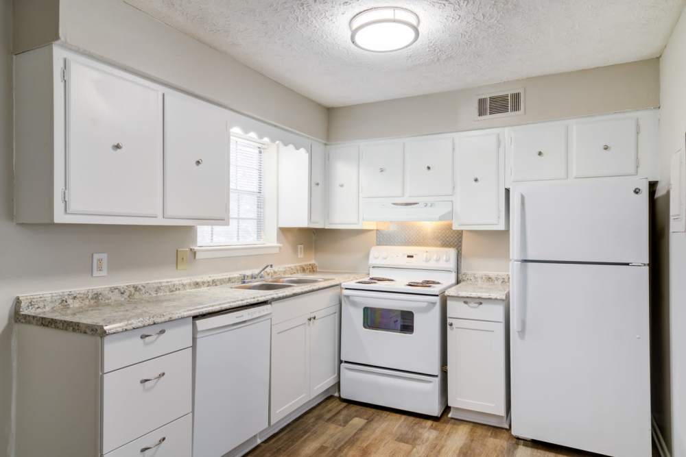 White cupboards and matching appliances in an apartment kitchen at Affinitee at Pine Lake in Stone Mountain, Georgia