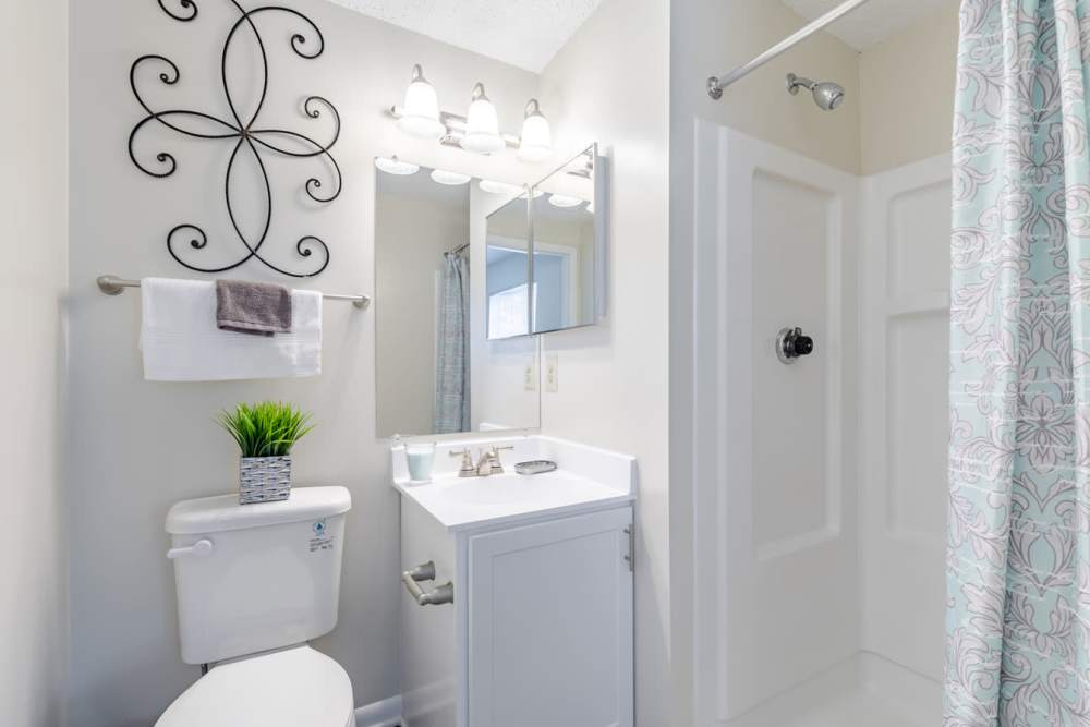 A bathroom with a mirror and sink at Kingscrest Apartments in Frederick, Maryland