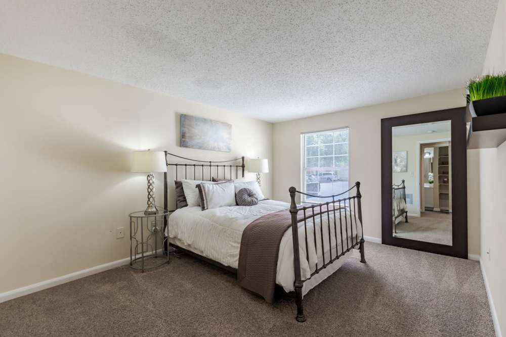 A bedroom with a mirror and a bed at Kingscrest Apartments in Frederick, Maryland