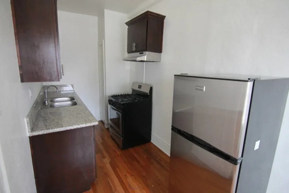 Kitchen with a refrigerator, range and hood at Westmoreland Apartments in Los Angeles, California