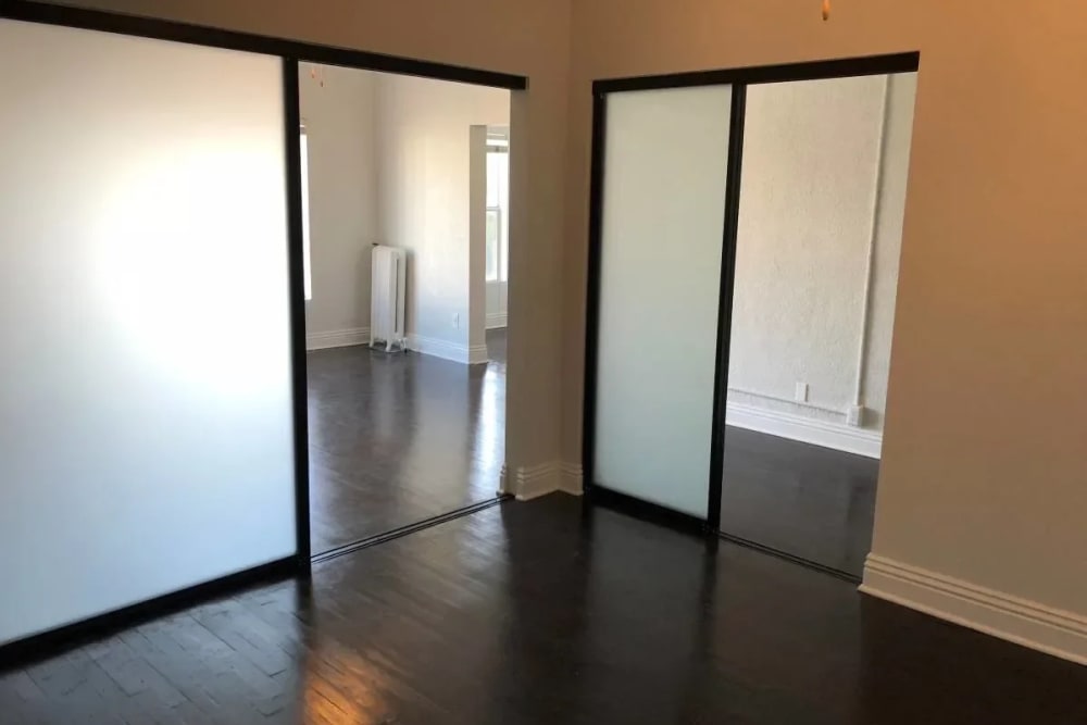 Forested glass door with hard wood flooring at Westmoreland Apartments in Los Angeles, California