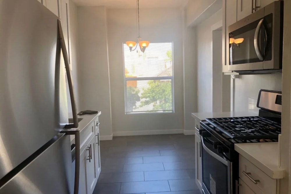 A modern kitchen with range, oven with beautiful hanging lights at Westmoreland Apartments in Los Angeles, California