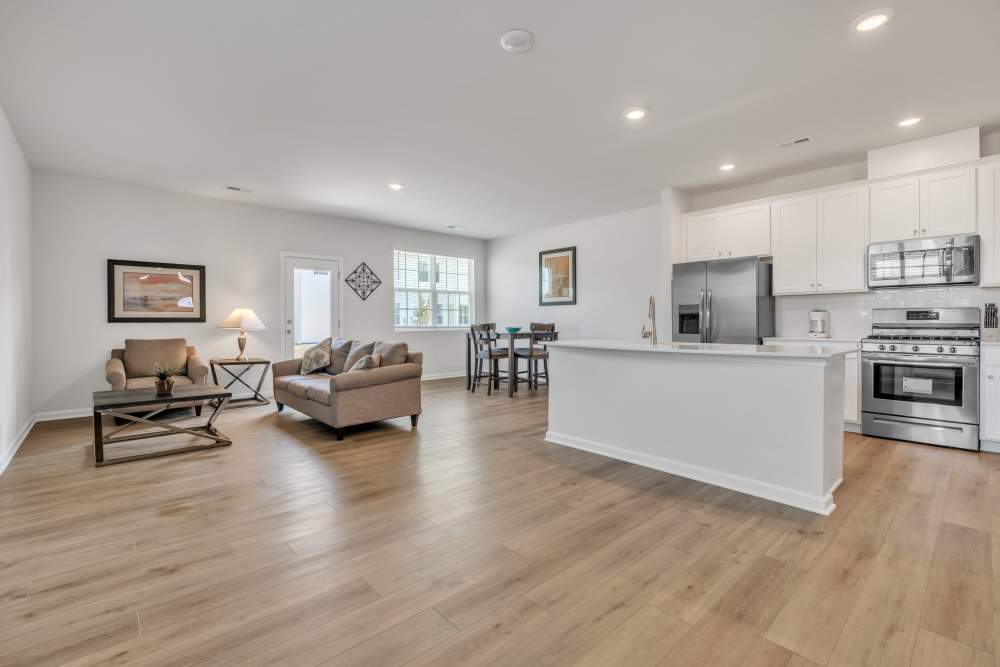 Wood-style flooring in a living room and kitchen at Eagle Chase in Taylors, South Carolina