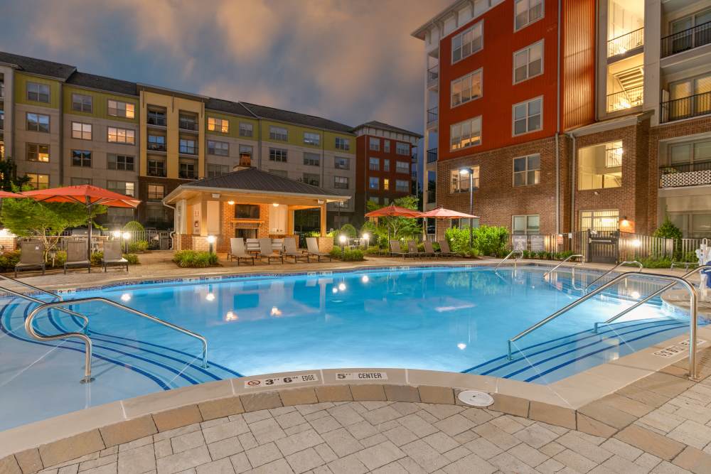 evening view of pool, pool deck and loungers with umbrellas at The District in Asheville, North Carolina