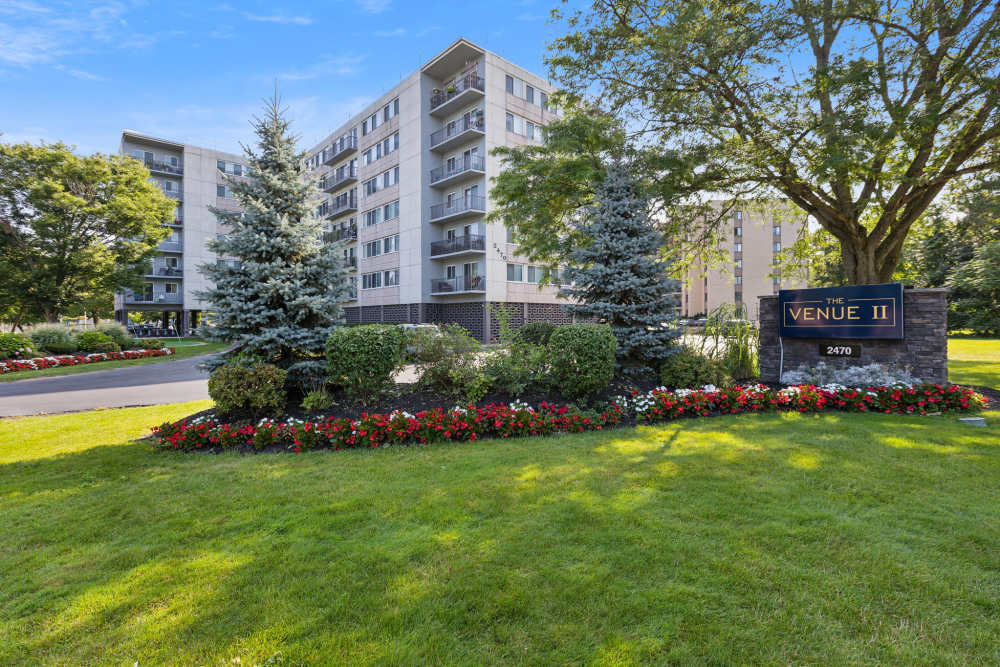 Scenic apartment complex with expansive green space and trees at The Venue in Rochester, New York