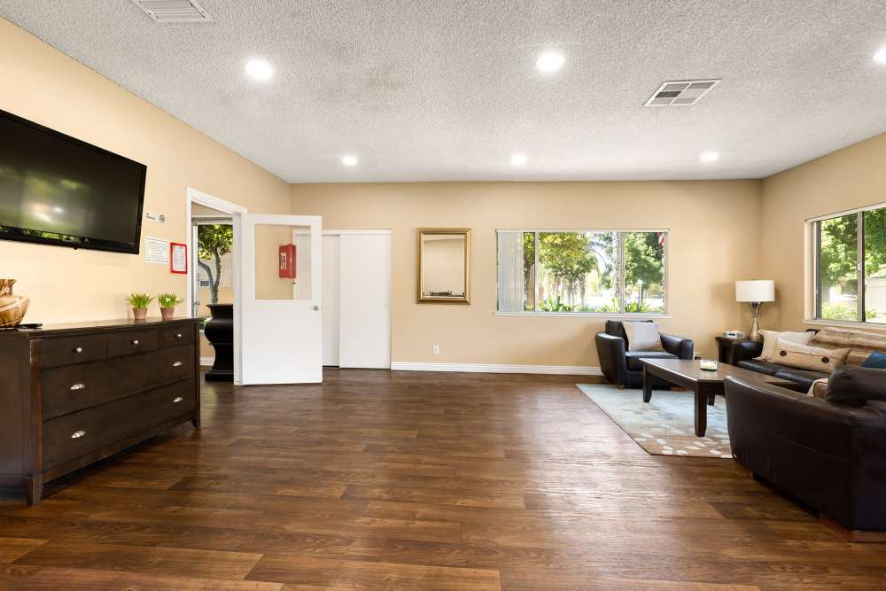Modern design clubhouse with large lounge chairs and televisions at Reseda Village Green in Reseda, California