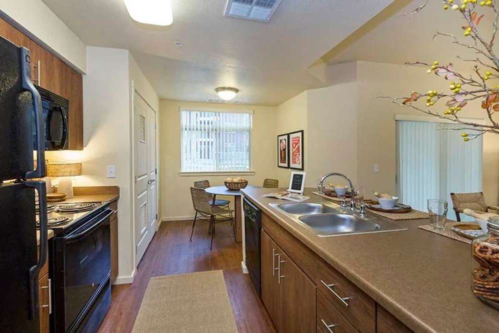 Spacious island kitchen, dishwasher, and wood cabinetry at Copper Valley in Puyallup, Washington