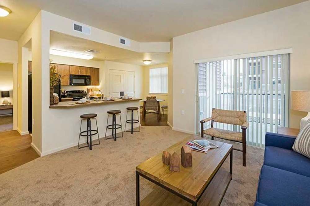 Open layout carpeted living room with plenty of room for a couch, coffee table, and more at Copper Valley in Puyallup, Washington