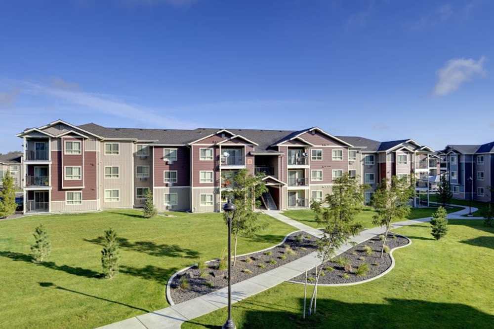 View of exterior of apartments and green lawn at Copper Trail in Olympia, Washington