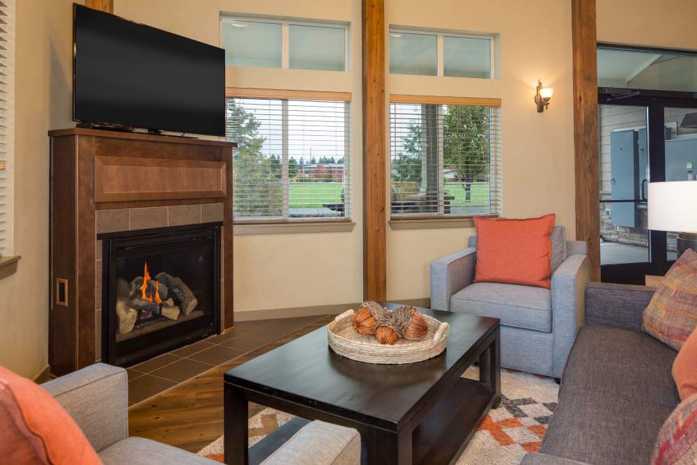 Modern design clubhouse with large lounge chairs and televisions at Copper Trail in Olympia, Washington