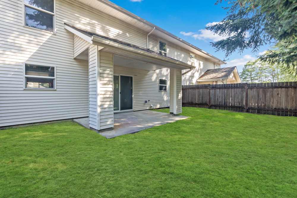 Exterior of back of the home with fenced backyard