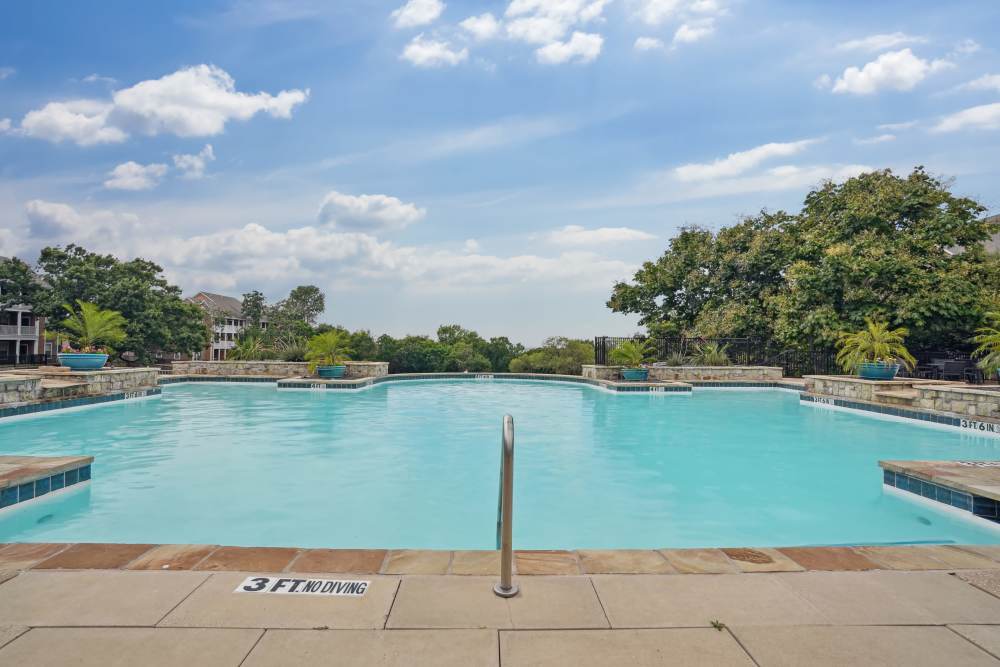 Pool area with lounge seating at Flatiron District at Austin Ranch in The Colony, Texas