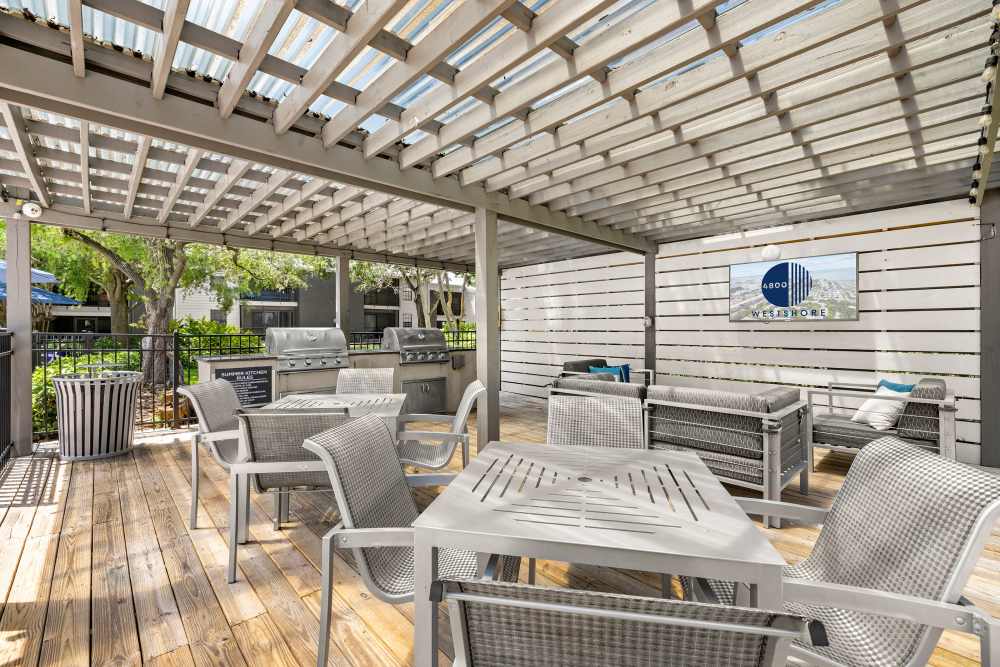 Outdoor patio with television, seating, and summer kitchen at 4800 Westshore in Tampa, Florida