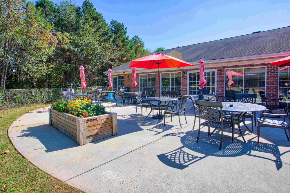 Exterior seating with umbrellas Clemmons Village Assisted Living and Memory Care in Clemmons, North Carolina