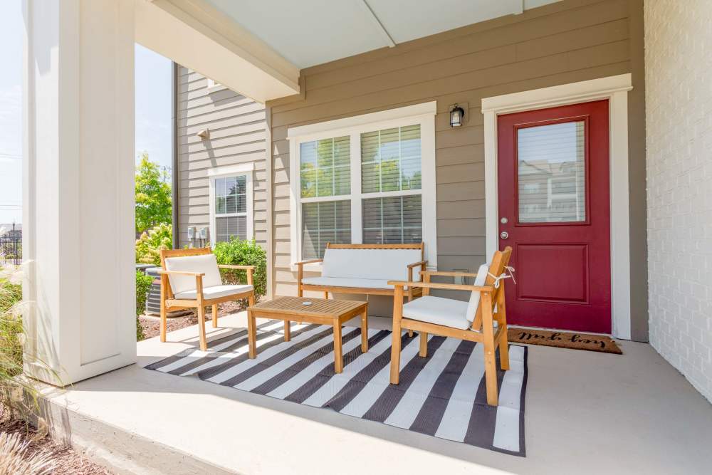 Covered porch with red front door and outdoor seating at Springfield Apartments in Murfreesboro, Tennessee