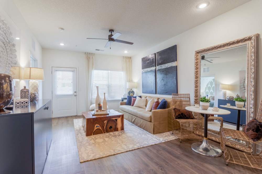 Living room with ceiling fan and leaning floor mirror at Springfield Apartments in Murfreesboro, Tennessee