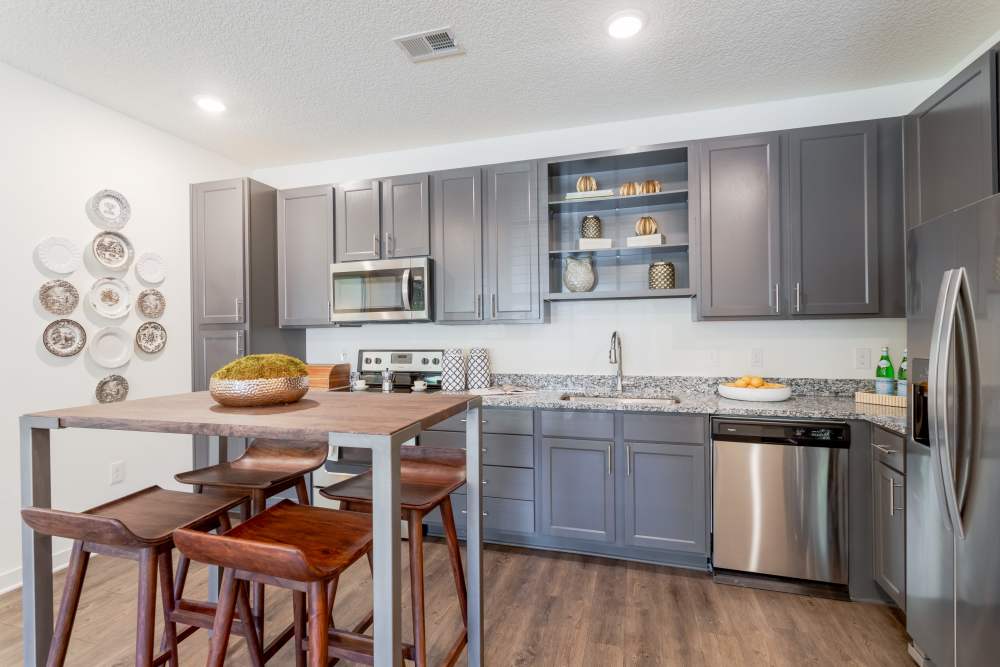 Kitchen with gray cabinets and breakfast bar seating at Springfield Apartments in Murfreesboro, Tennessee